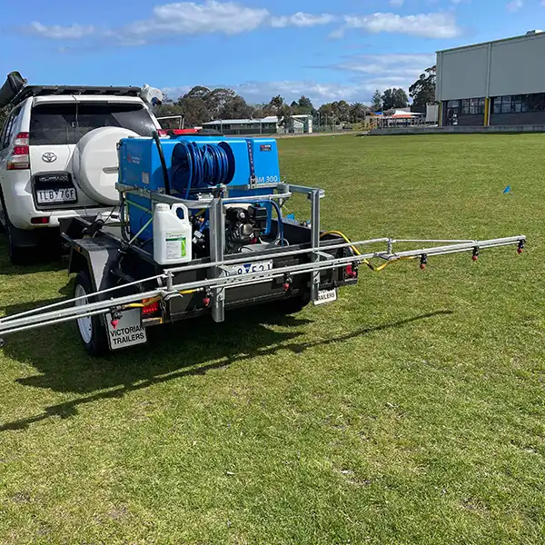 an image of a sprayer adding marker dye for reseeding of school oval